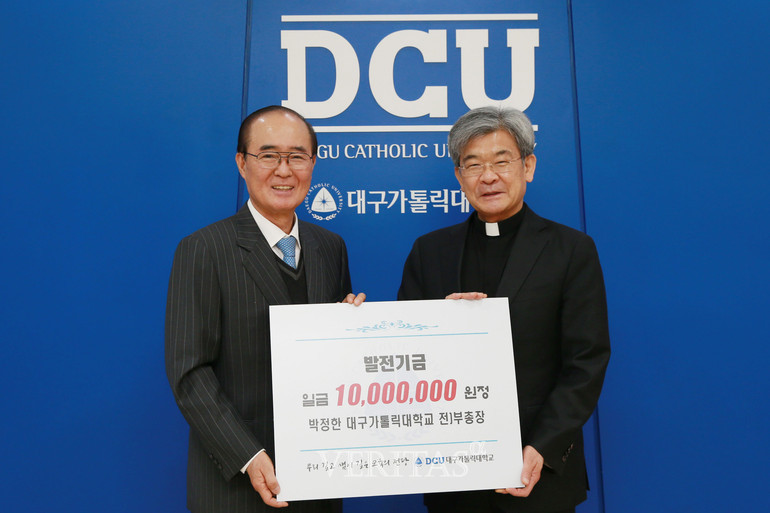 대구가톨릭대 박정한 전 부총장(사진 왼쪽)이 김정우 총장에게 발전기금을 전달하고 있다. /사진=대구가톨릭대 제공