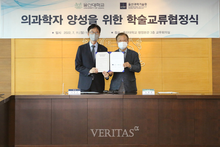 오연천 울산대 총장(오른쪽)과 이용훈 UNIST 총장(왼쪽)이 11일 울산대 행정본관 3층 교무회의실에서 양 대학 관계자들이 참석한 가운데 체결한 ‘의과학자 양성을 위한 학술교류 협정서’를 들고 있다. /사진=UNIST 제공